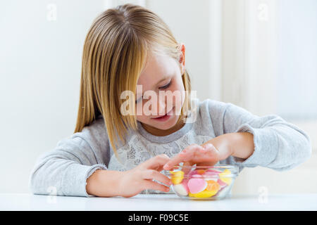 Portrait de bel enfant de manger des bonbons à la maison. Banque D'Images