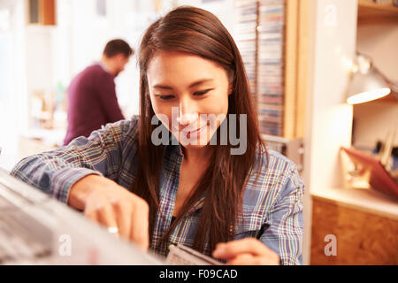 Femme à la recherche d'un enregistrement à un magasin de disques Banque D'Images