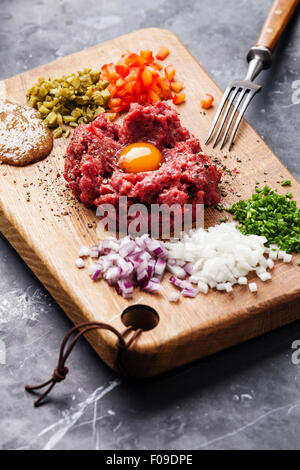 Tartare de boeuf cornichon et oignons frais sur fond de marbre noir Banque D'Images