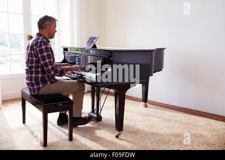 Apprendre à jouer du piano Man Using Digital Tablet Application Banque D'Images