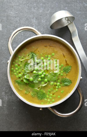 Soupe aux pois verts dans une casserole en aluminium garnis de menthe fraîche Banque D'Images