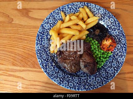 Steak et frites repas sur une plaque bleu et blanc. Banque D'Images