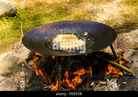 Le pain perdu cuit sur un feu de camp dans la forêt de pins Banque D'Images