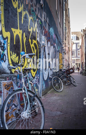 Vélo dans une ruelle à Amsterdam, sur un mur de graffiti urbain Banque D'Images