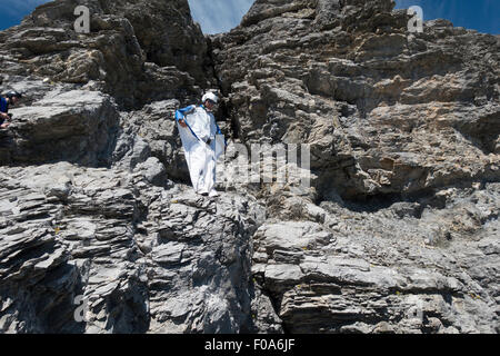 Cavalier BASE Wingsuit s'apprête à sauter d'une falaise et contrôle de l'altitude par vers le bas et réglage de ses ailes. Banque D'Images