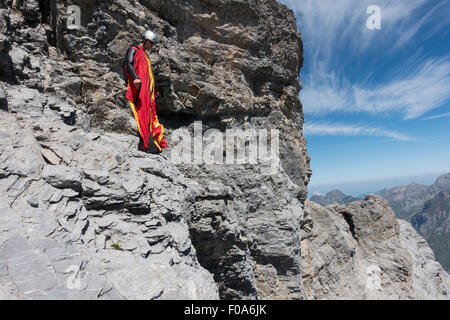 Cavalier BASE Wingsuit s'apprête à sauter d'une falaise et contrôle de l'altitude par vers le bas et réglage de ses ailes. Banque D'Images