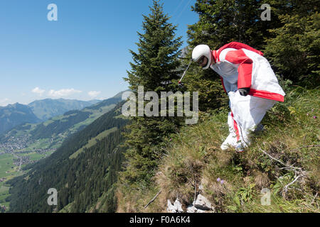 Cavalier BASE Wingsuit s'apprête à sauter d'une falaise et contrôle de l'altitude par vers le bas et réglage de ses ailes. Banque D'Images