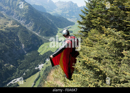 Cavalier BASE Wingsuit s'apprête à sauter d'une falaise et contrôle de l'altitude par vers le bas et réglage de ses ailes. Banque D'Images