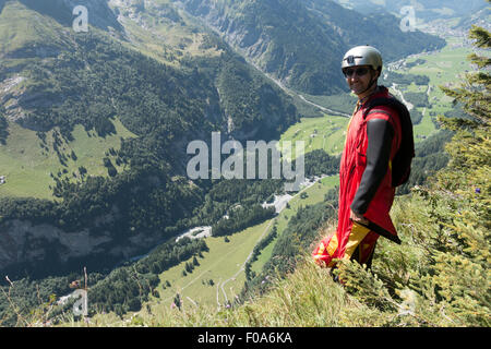 Cavalier BASE Wingsuit s'apprête à sauter d'une falaise et donne un dernier sourire avant de sauts. Banque D'Images