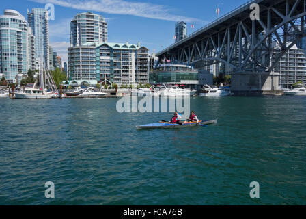 Deux femme kayak à False Creek à Vancouver, par le pont Granville. Yaletown condo towers le long de la mer. Banque D'Images