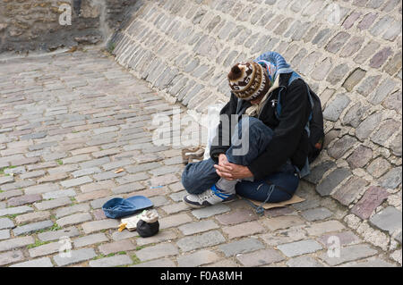 PARIS, FRANCE - 27 juillet 2015 : un sans-abri est assis et mendier pour de l'argent dans une rue de Paris en France Banque D'Images