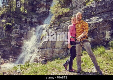 Les grimpeurs hugging, cascade en arrière-plan, Ehrwald, Tyrol, Autriche Banque D'Images