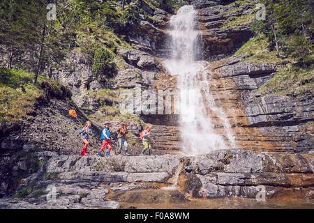 Groupe d'enfants explorer en cascade Banque D'Images