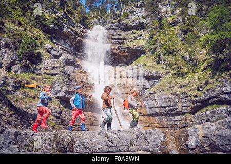 Groupe d'enfants explorer en cascade Banque D'Images