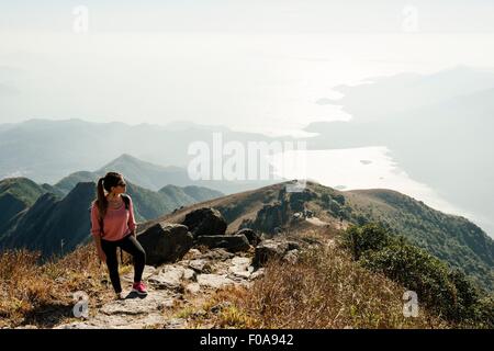 Jeune femme randonneur sur pic de Lantau à loin, Lantau Island, Hong Kong, Chine Banque D'Images