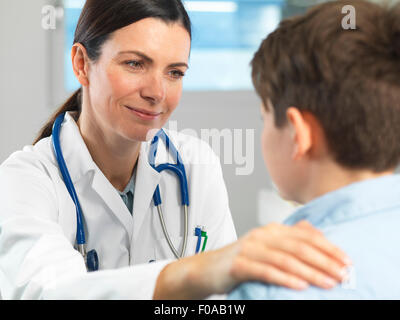 Jeune garçon réconfortant médecin en clinique Banque D'Images