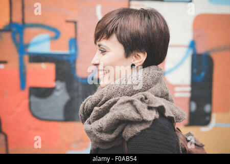 Jeune femme par le graffiti wall Banque D'Images