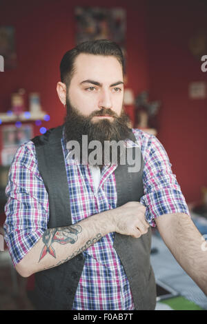 Jeune homme barbu manchon chemise de pliage Banque D'Images