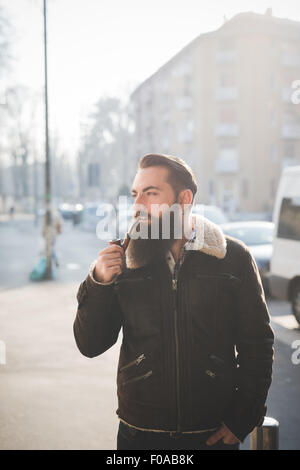 Jeune homme barbu pipe on street Banque D'Images