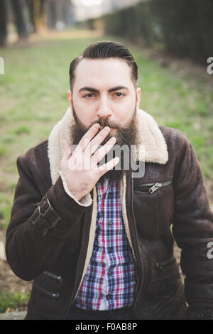 Jeune homme barbu en parc, Milan, Italie Banque D'Images