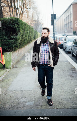 Jeune homme barbu sur la chaussée Banque D'Images