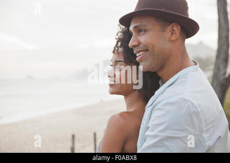 Smiling couple looking out sur beach, Rio de Janeiro, Brésil Banque D'Images