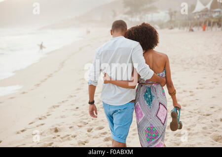 Vue arrière du couple strolling on beach, Rio de Janeiro, Brésil Banque D'Images