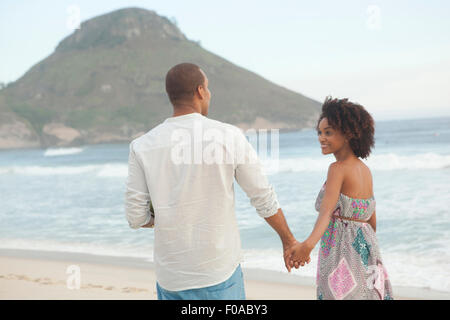 Couple strolling main dans la main sur la plage, à Rio de Janeiro, Brésil Banque D'Images