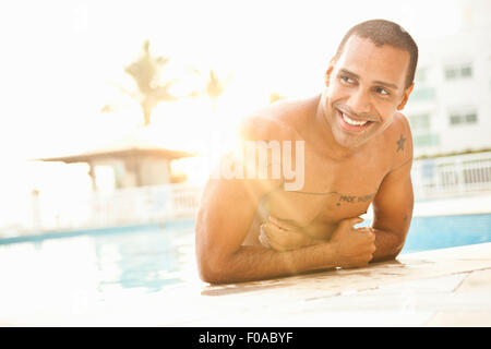 Mid adult man standing in sunlit piscine de l'hôtel, Rio de Janeiro, Brésil Banque D'Images