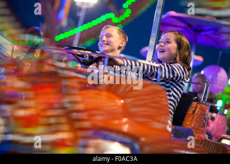 Frère et soeur sur parc d'ride de nuit Banque D'Images