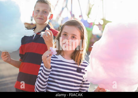 Frère et soeur Rose manger candyfloss à fairground Banque D'Images