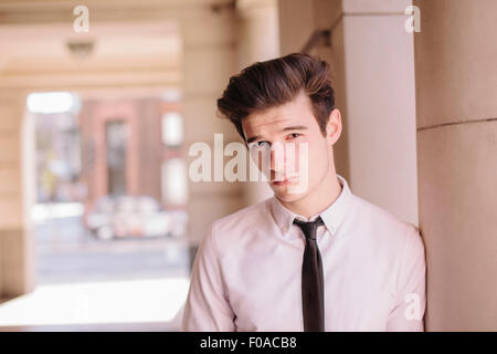 Portrait of young businessman appuyé contre le pilier de la ville Banque D'Images