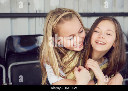 Portrait of two smiling girls hugging in stadium stand Banque D'Images