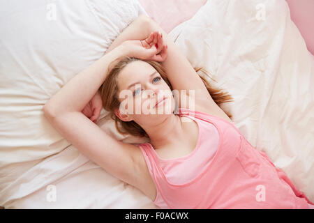 Girl lying on bed le regard vers le haut Banque D'Images