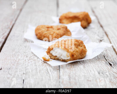 Trois morceaux de cabillaud pané frit chunky sur table en bois Banque D'Images