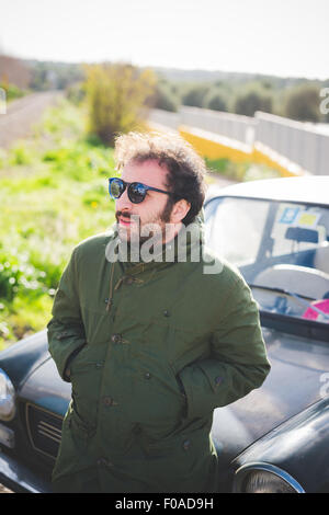 Mid adult man in front of vintage car Banque D'Images