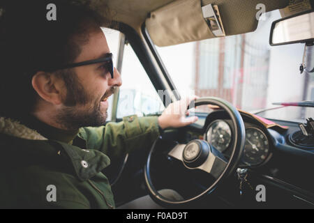 Mid adult man smiling en voiture d'époque Banque D'Images