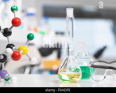 Verrerie de laboratoire et la structure moléculaire assis sur une table de laboratoire au cours d'une expérience Banque D'Images