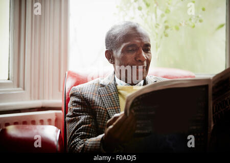 Senior man reading newspaper Banque D'Images