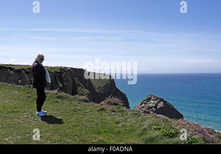 Femme debout sur une falaise. CORNWALL UK. Banque D'Images