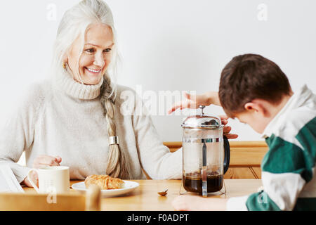 Grand-mère et petit-fils faire le café dans la cafetière Banque D'Images