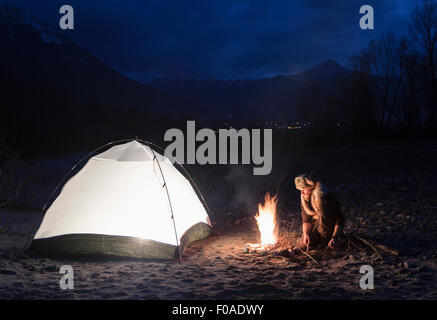 Par l'homme de camp et tente de nuit Banque D'Images