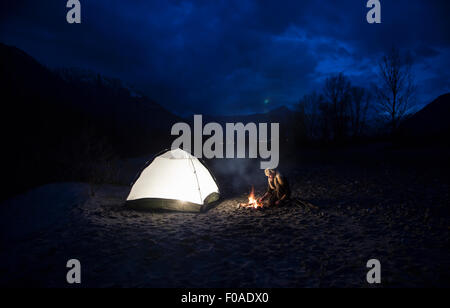 Par l'homme de camp et tente de nuit Banque D'Images