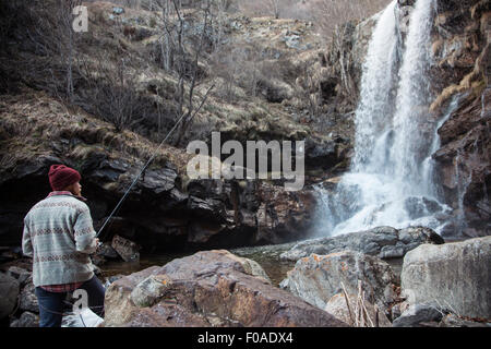 Man fishing par cascade, rivière Toce, Premosello, Verbania, Piedmonte, Italie Banque D'Images