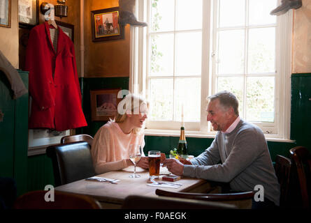 Couple drinking et bavarder dans pub Banque D'Images