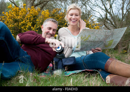 Randonnées couple reading map on picnic blanket Banque D'Images