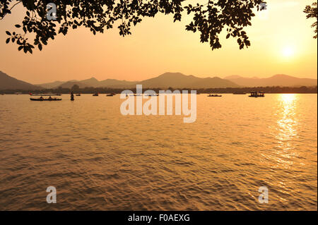 Bateaux sur le lac au coucher du soleil, Hangzhou, Chine Banque D'Images