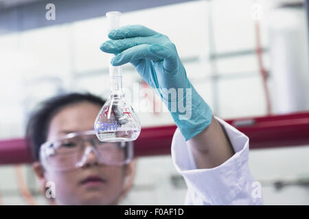 Female scientist holding fiole jusqu'au laboratoire Banque D'Images