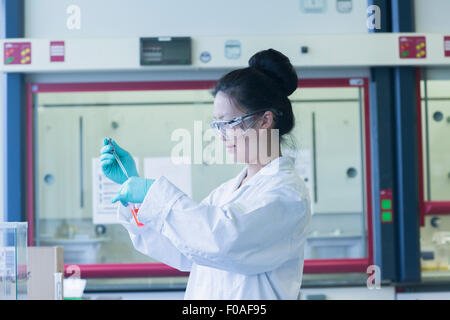 Female scientist in lab prélever dans un bécher de laboratoire Banque D'Images