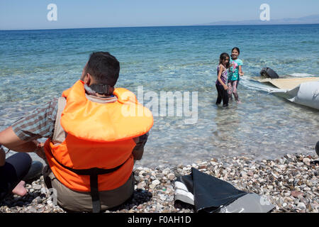 Chios, Grèce. 21 juillet, 2015. Les réfugiés en provenance de Syrie arrivent dans overladen canot en caoutchouc sur l'île grecque de Chios. Les 60 occupants du bateau sont arrivés après 5 heures en mer et trois jours à pied soulagés et heureux de poser le pied sur le sol européen après une évasion de la combattre en Syrie. Chios, Grèce. Crédit : Mike Abrahams/Alamy Live News Banque D'Images